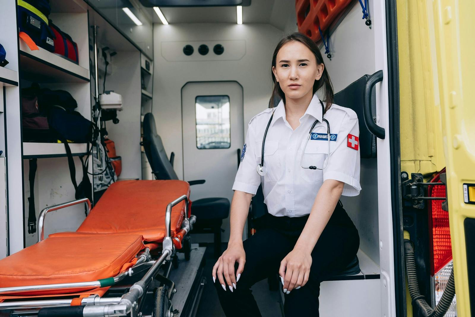 Paramedic Sitting by a Stretcher in the Back of an Ambulance