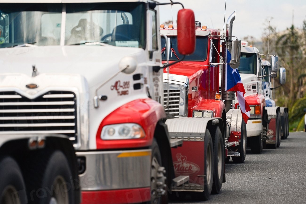 Flatbed and open deck trucks staged for loading